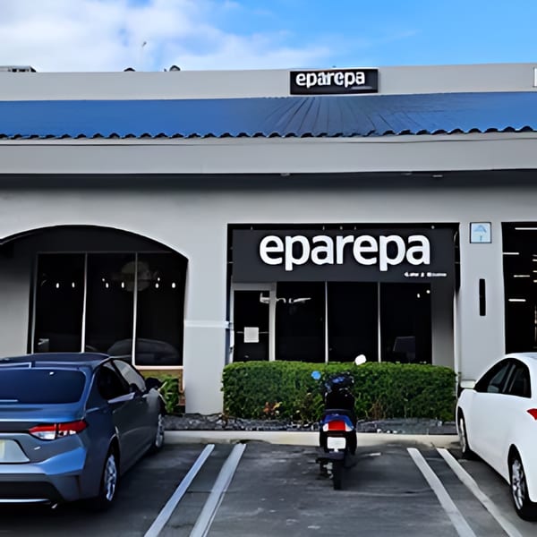 The Eparepa restaurant storefront with a blue awning, cars, and a scooter parked outside.